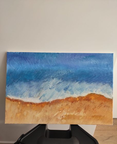 Strandlandschaft mit blauen Wellen und goldenem Sand.