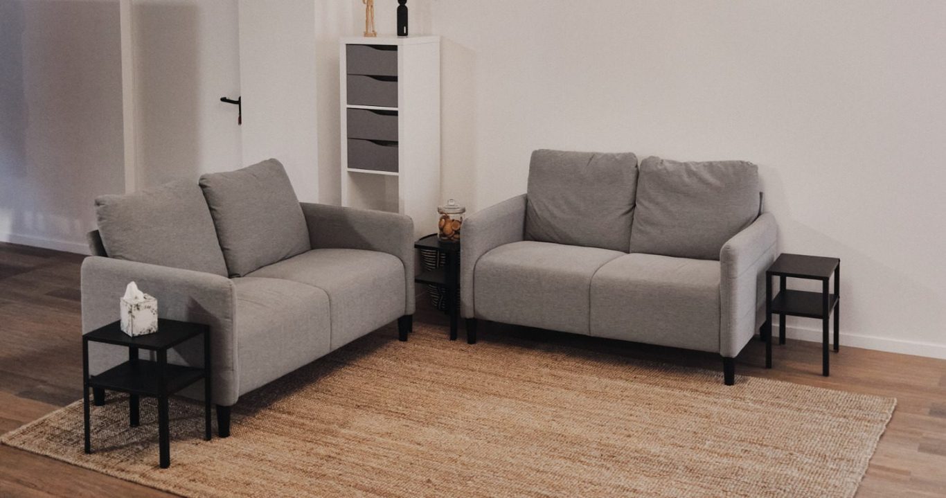 Leerer Raum mit Stuhlkreis, Tisch, Bücherregal und Wandtafel.