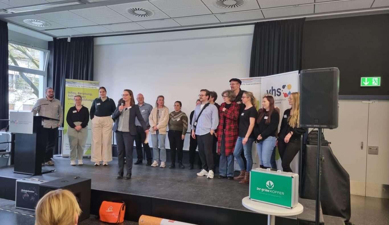 Zwei lächelnde Personen sitzen in einem Café und unterhalten sich.