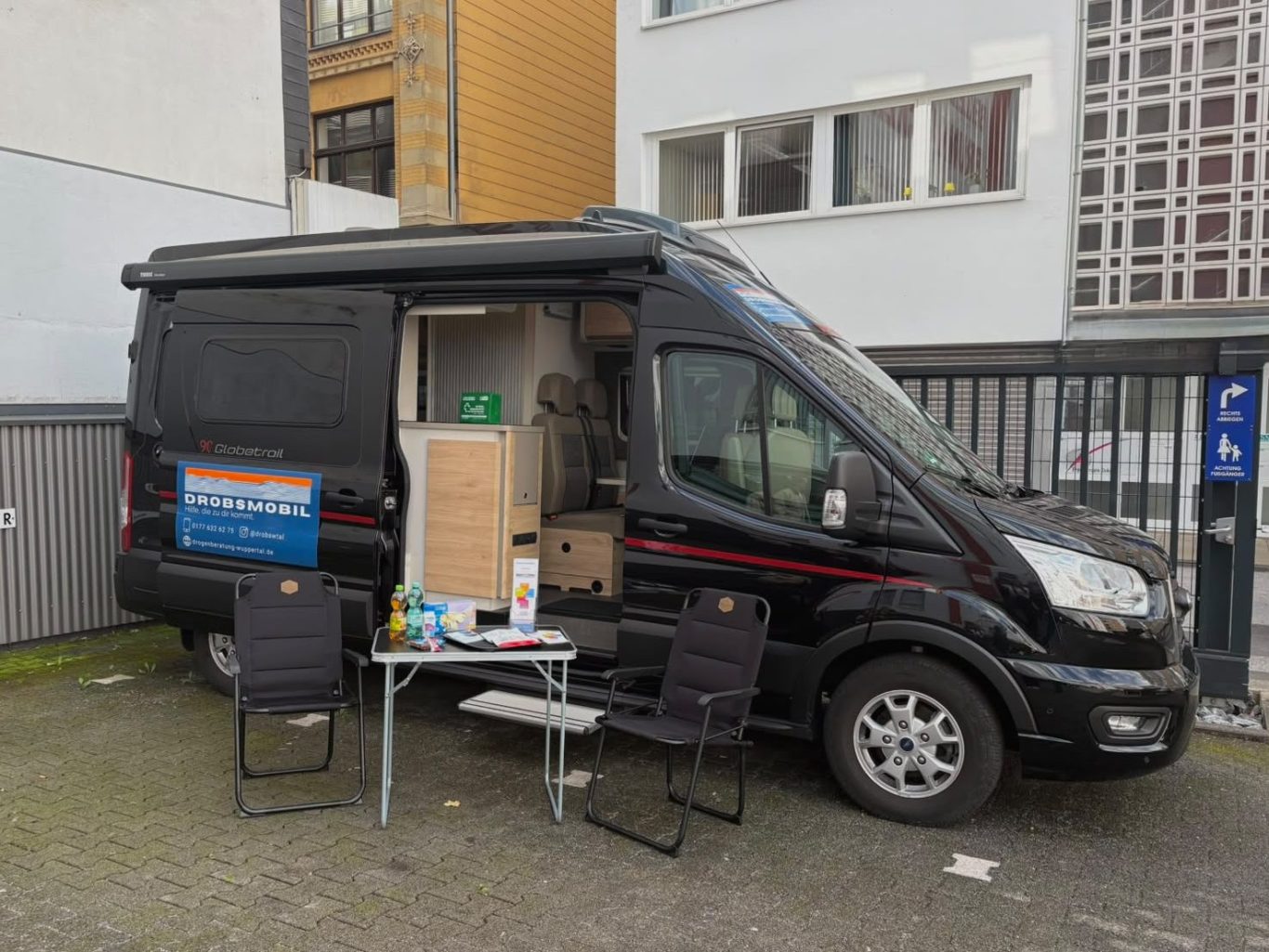 Zwei lächelnde Personen sitzen in einem Café und unterhalten sich.