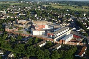 Luftaufnahme eines Industriegebiets mit mehreren großen Gebäuden und umliegender Landschaft.