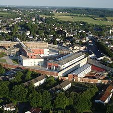 Luftaufnahme eines Stadtteils mit modernen Gebäuden und grünen Flächen.